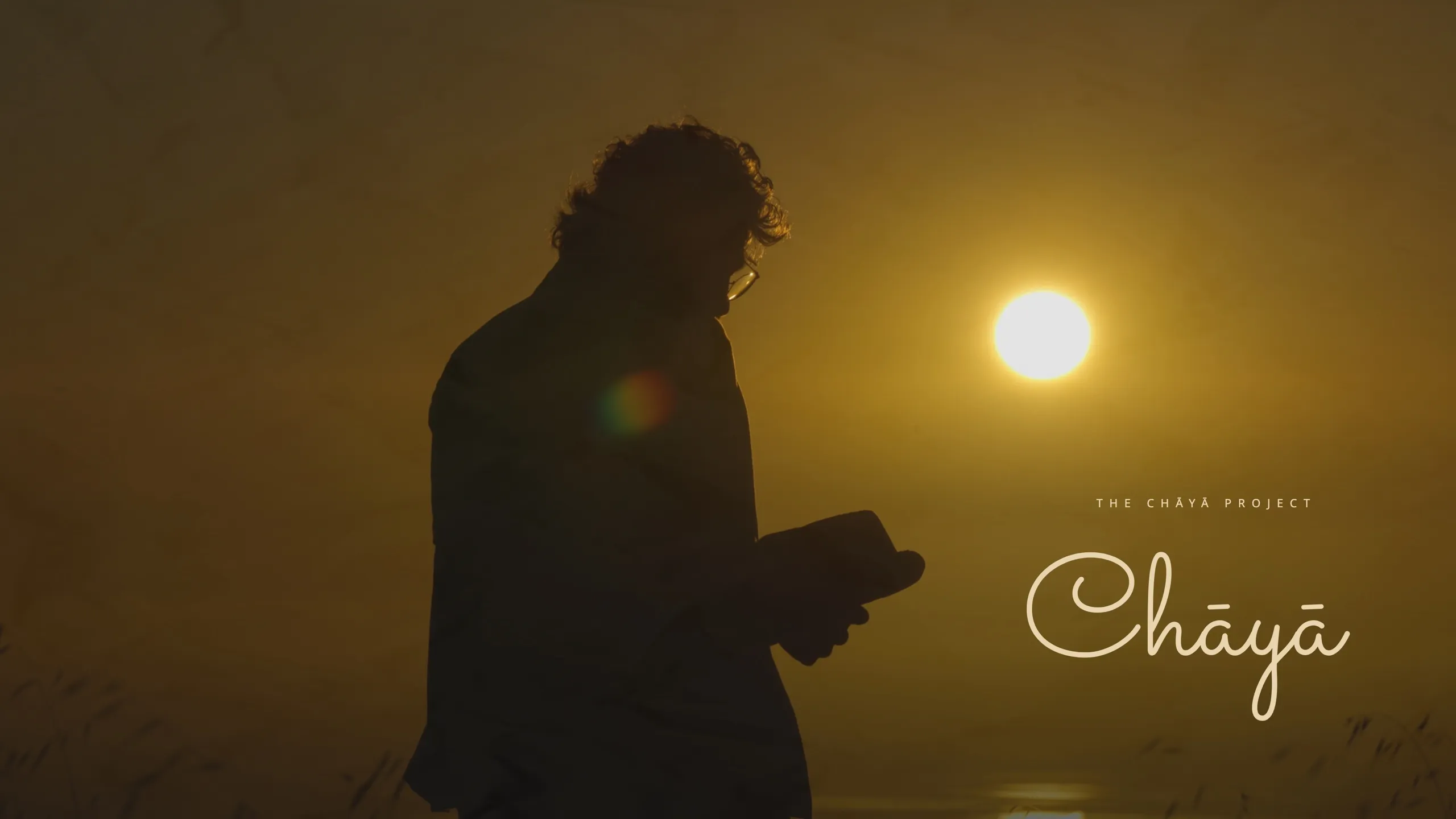 Chāyā — a figure reading against the sunrise