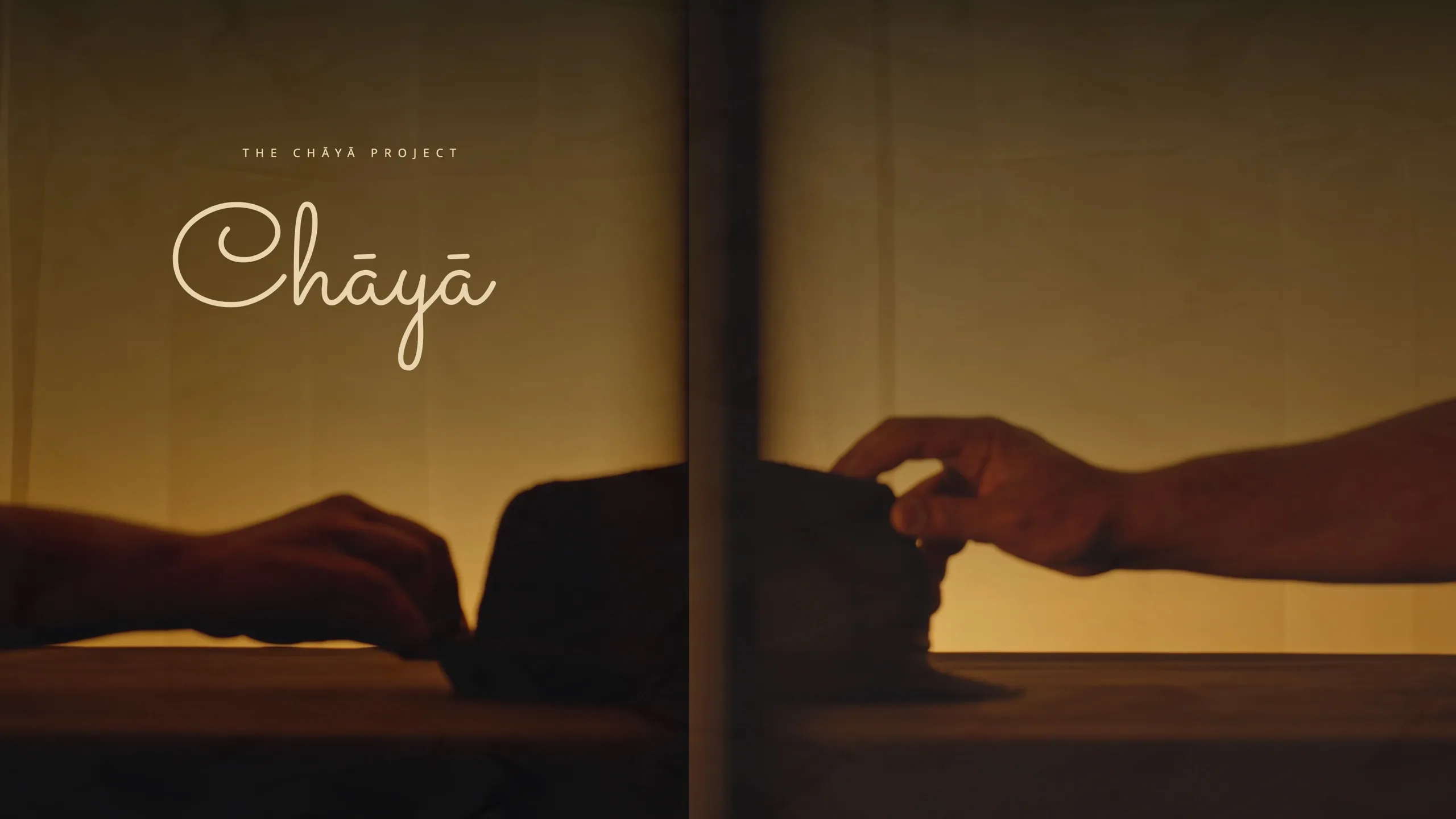 Chāyā — two hands reaching across a divided frame